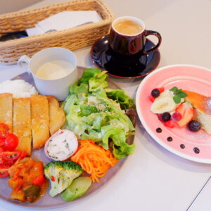 福島市にあるROY CAFEのヒレカツ列。プレートにトマトやブロッコリーなど彩の豊かなおかずと特製ヒレカツレツが盛られている。右側には特製ケーキ。