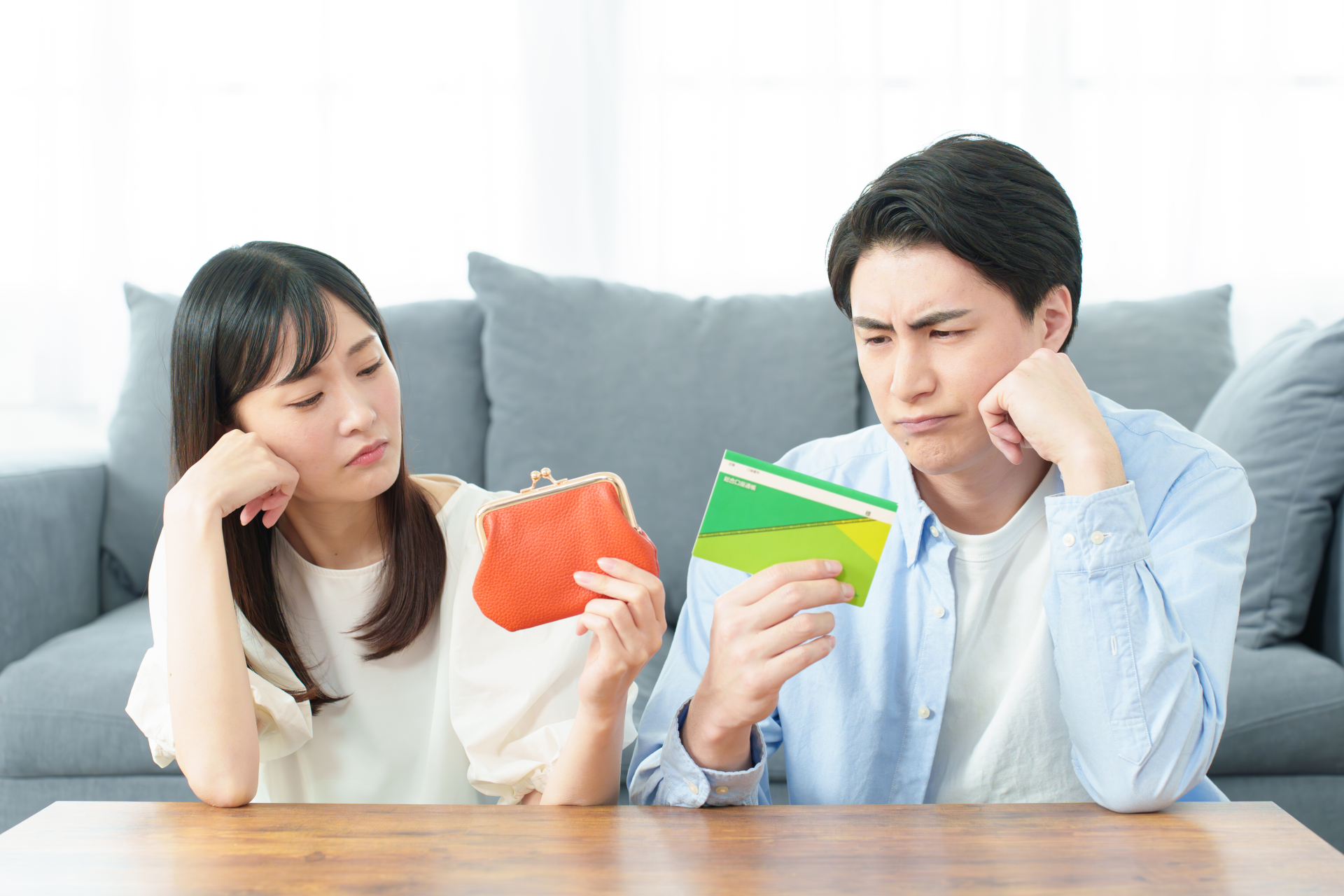 女性と男性が通帳を見て悩んでいる様子
